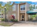 Charming two-story home with a covered carport, vibrant foliage, and manicured lawn at 9046 Lake Place Ln # 9046, Tampa, FL 33634