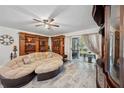 Spacious living room featuring a unique curved couch, decorative shelving, and sliding glass doors at 9046 Lake Place Ln # 9046, Tampa, FL 33634