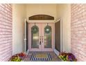 Close up of front door, featuring wreath decorations, hardware and welcome mat at 1038 Greenturf Rd, Spring Hill, FL 34608