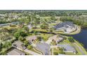Scenic aerial view of the community featuring lush landscaping, community amenities, and tranquil pond at 11428 Hidden Cove Ct, Trinity, FL 34655