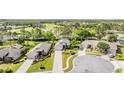 Overhead view of neighborhood showcasing well-manicured lawns, mature trees, and proximity to a golf course at 11428 Hidden Cove Ct, Trinity, FL 34655