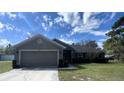 Lovely single-story home showcasing its front lawn, attached two-car garage and a welcoming entrance at 12342 Quigley Ave, Weeki Wachee, FL 34614