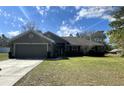 Charming single-story home with a well-maintained lawn and attached two-car garage at 12342 Quigley Ave, Weeki Wachee, FL 34614
