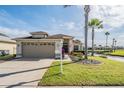 Inviting home featuring lush landscaping, a two-car garage, and an attractive exterior waterfront view at 1809 Westerham Loop, Trinity, FL 34655