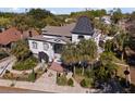 Bird's eye view of an ornate home with black-and-white accents, a dark roof, and a lush yard with palm trees at 200 Grand Blvd, Tarpon Springs, FL 34689