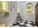 Elegant hallway with arched windows, stained glass, and black and white checkered marble flooring at 200 Grand Blvd, Tarpon Springs, FL 34689