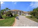 Stunning single-story house with a paved driveway surrounded by lush greenery and palm trees at 2375 Fairskies Dr, Spring Hill, FL 34606