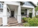 Inviting front porch with classic columns, brick-paved steps, and decorative landscaping at 2596 Whittler Br, Odessa, FL 33556