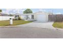 Charming single-story home featuring a well-manicured lawn and a welcoming front entrance with decorative concrete fencing at 2620 Baltic Pl, Holiday, FL 34691