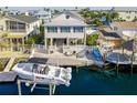 Waterfront home featuring a boat lift, private dock, and outdoor entertaining area with lush landscaping at 4058 Centavo Ct, Hernando Beach, FL 34607