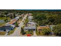 An aerial shot showcasing the neighborhood with lush greenery, nearby lake, and the home's proximity to nature at 4107 Glissade Dr, New Port Richey, FL 34652