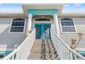 Stairs lead to the home's inviting entryway, featuring detailed double doors and a color-coordinated trim at 4207 Carlos Ct, Hernando Beach, FL 34607
