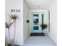 Inviting front door with a turquoise frame, complemented by elegant potted plants, and updated hardware at 4936 Dory Dr, New Port Richey, FL 34652