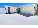 Front exterior of updated waterfront home with a freshly painted driveway, metal roof, and a well-manicured yard at 4936 Dory Dr, New Port Richey, FL 34652