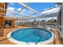 Screened pool boasts clear blue water with patio and view of canal homes, perfect for relaxing at 5000 Southshore Dr, New Port Richey, FL 34652