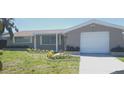 Charming single Gathering home features well-maintained front yard and attached one car garage at 7024 Coral Reef Dr, Port Richey, FL 34668
