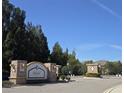 Stone community entrance sign with wrought iron gates and lush landscaping at 8405 Blue Rock Dr, New Port Richey, FL 34653