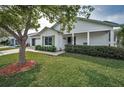 Charming single-story home with a well-maintained lawn, mature tree, and a welcoming front porch at 9336 Cape Charles Ave, New Port Richey, FL 34655