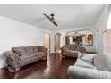 Inviting living room with hardwood floors, ceiling fan, and an open view to the kitchen, great for entertaining at 10399 Elgin Blvd, Spring Hill, FL 34608