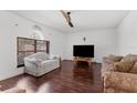 Bright living room featuring hardwood floors, a ceiling fan, and a large window that provides natural light at 10399 Elgin Blvd, Spring Hill, FL 34608