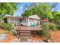 View of a home with a wooden deck, outdoor furniture, and lush landscaping at 11326 Minnieola Dr, New Port Richey, FL 34654