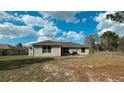 View of the back of the home, showcasing a large yard with ample space for outdoor activities at 13066 Painted Bunting Ave, Weeki Wachee, FL 34614