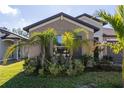 Exterior elevation with stucco and lush landscaping, and a dark trim at 1957 Fan Aloe Way, Ruskin, FL 33570