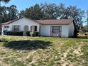 Charming single-story home boasting a classic fountain, red door/window accents, and mature landscaping at 2335 Canfield Dr, Spring Hill, FL 34609