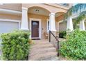 Charming front porch featuring brick steps, decorative columns and cozy seating area at 2506 W Ivy St, Tampa, FL 33607