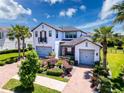 Beautiful two-story home with a three car garage, a brick driveway, and lush landscaping at 2630 Milford Berry Ln, Tampa, FL 33618
