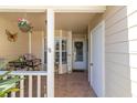 Inviting front porch featuring tile flooring, seating, decor, and a front door with decorative wreath at 6420 Cabbage Ln, New Port Richey, FL 34653