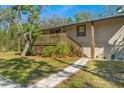 Charming home exterior with wooden deck, stone pathway, and vibrant landscaping at 7240 Creek Dr, New Port Richey, FL 34655