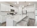 Modern kitchen with white cabinets, stainless steel appliances, and a large center island with seating at 778 Parsons Mooring Ct, Seffner, FL 33584