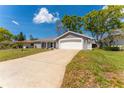 Single-story home boasts a neatly manicured lawn and attached two-car garage at 8705 Village Mill Row, Hudson, FL 34667