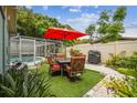 Private backyard featuring a dining area, grill, and lush greenery, perfect for outdoor entertaining and relaxation at 9040 Mark Twain Ln, Port Richey, FL 34668