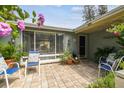 Inviting front porch with brick pavers, comfortable seating, and potted plants offering a welcoming entrance at 9040 Mark Twain Ln, Port Richey, FL 34668