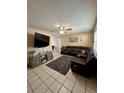 Spacious living room with tile floors, a ceiling fan, large leather sectional, and a contemporary entertainment center at 9350 Barrington Ln, Port Richey, FL 34668
