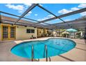 Sparkling in-ground pool surrounded by a screened enclosure and patio, perfect for outdoor entertaining at 11256 Holbrook St, Spring Hill, FL 34609