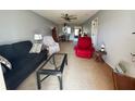 Living room with carpet, sofa, arm chairs, ceiling fans, and connected dining area at 11310 Carriage Hill Dr # 4, Port Richey, FL 34668