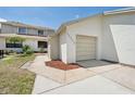 Home exterior showing attached garage and walkway at 11735 Rolling Pine Ln, Port Richey, FL 34668