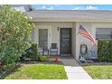 Charming front porch with chairs, an American flag, and well-maintained landscaping at 12505 Dearborn Dr # C, Hudson, FL 34667