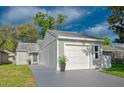 Neat single-story home featuring a one-car garage and simple, tidy landscaping at 152 Chelsea Ct, Dunedin, FL 34698