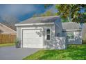 Home featuring an attached one-car garage and a small, well-kept lawn at 152 Chelsea Ct, Dunedin, FL 34698