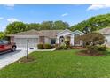 Charming single-story home featuring a well-manicured lawn and beautiful landscaping at 2309 Terrace View Ln, Spring Hill, FL 34606