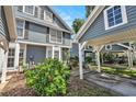 Well-maintained townhome exterior featuring covered parking, lush landscaping, and blue siding at 290 Winchester Way, Palm Harbor, FL 34684