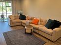 Spacious living room featuring a large sectional sofa, wood floors and stylish decor at 3037 Jacob Crossing Ln, Holiday, FL 34691