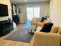 Comfortable living room with wood floors, large sectional sofa, and sliding door to patio at 3037 Jacob Crossing Ln, Holiday, FL 34691