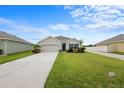 Inviting single-story home with green lawn, featuring a two-car garage and cozy front yard landscaping at 30639 Summer Sun Loop, Wesley Chapel, FL 33545