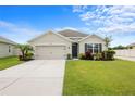 Charming single-story home showcasing a well-maintained lawn, two-car garage, and lovely front yard at 30639 Summer Sun Loop, Wesley Chapel, FL 33545