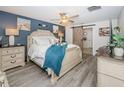 Comfortable bedroom with blue accent wall, sliding barn door, and wood look flooring at 36419 Flats St, Zephyrhills, FL 33541